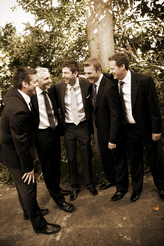 His groomsmen wore black suits from Suits On Q with black stripe ties